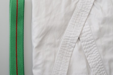 karate equipment : green belt, kimono on light background