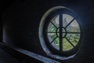rundes fenster in einem dunklen dachgeschoss