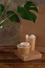 Street fast food paper cups, plates and containers. Eco-friendly food packaging on wooden background. Carering of nature and recycling concept.