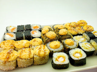 Rectangular plate full of hand-rolled sushi, sushi set, close-up.
