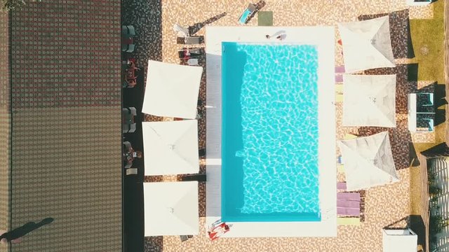 Top view of the pool. Rectangular pool and umbrellas with loungers