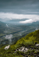 Fototapeta na wymiar View on green valley and mountain range on cloudy day