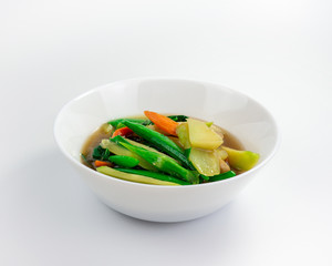 Stir-fried vegetables with peas, kale and carrots on white background