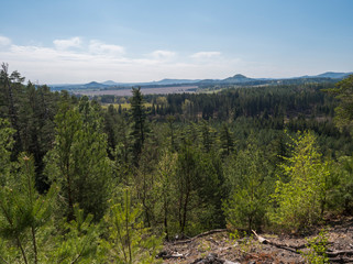 Spring landscape in Lusatian Mountains view from sandstone rocks, green hills, fresh deciduous and spruce tree forest. Blue sky background, horizontal, copy space