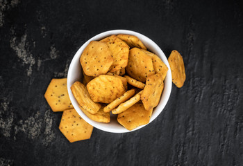 Mixed Snacks on dark background (close up shot; selective focus)