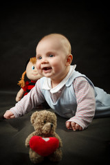 little baby surrounded by toys