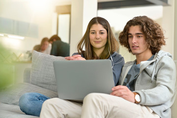 Fototapeta na wymiar Young couple of students at home watching movie on laptop
