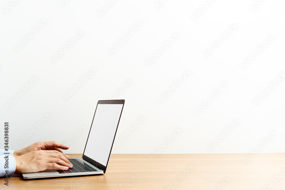 Aufkleber using laptop computer with blank display on wood table. businessman typing laptop.
