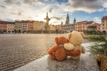 Two Teddy bears in love looking on the sunset in the medieval city České Budějovice.