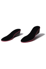 Subject shot of two black insoles with velour surface, red interlayer and printed heel pads. The height increasing insoles are isolated on the white backdrop. 