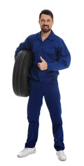 Fototapeta premium Full length portrait of professional auto mechanic with wheel on white background