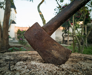 Ancient ax, nailed to a large log of wood