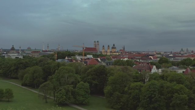 Smooth aerial swing over the Englisch Garden in the bavarian capital Munich with several sightseeing architectures. Wide view over the wonderful city at the early morning at springtime.