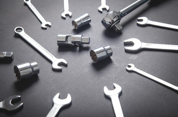 Different sizes wrenches on the black background.