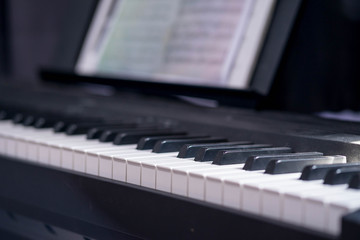 closeup side view of piano keyboard with low light