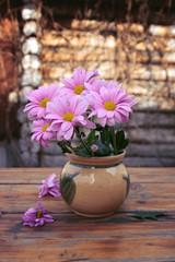 Spring flowers in a vase on the table. Multi-colored summer bouquets of chrysanthemums. The concept of summer bouquets. Allergy to flowers. Home garden. Decor and comfort in the house.