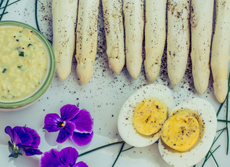 Bunch of fresh uncooked white asparagus and boiled eggs, new harvest, close up. Filter effect.  seasonal vegetables. Selective focus