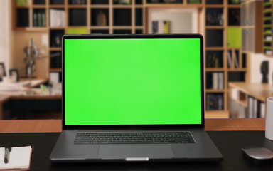Laptop computer with Green screen Mock-up on working desk in office with no people - Powered by Adobe