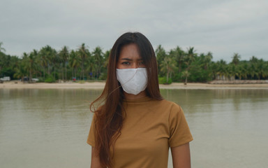 Portrait of Serious Asian Girl wearing protective Mask during Corona Virus pandemic stays on the...
