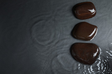 Stones in water on grey background, flat lay with space for text. Zen lifestyle