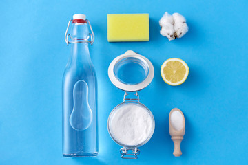 natural cleaning stuff and eco living concept - lemon, washing soda, bottle of vinegar, sponge and...