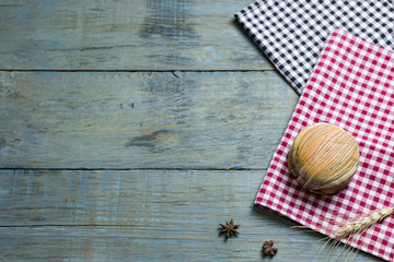 fresh bread put on red.scottish pattern fabric with grains on old wooden table background.Top view with copy space and selective focus.