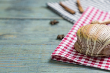 fresh bread put on red.scottish pattern fabric with grains on old wooden table background.With copy space and selective focus.
