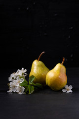 still life with pears on a black background
