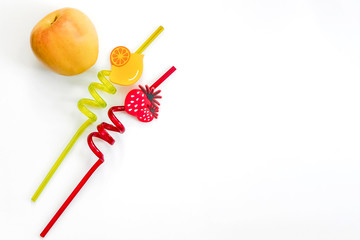 Apple and drink straws on a white background.