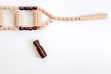 Massage accessories on a white background. Items for Spa treatments. Hand massager and massage oil on a white background.Wooden set for anti-cellulite manual massage.