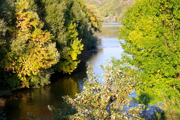 Idyllischer Fluß umgeben von Bäumen im Herbst