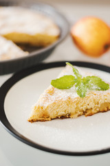 Slice of homemade apple pie with powdered sugar and fresh mint. Traditional dessert