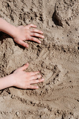 children's hands play with sand
