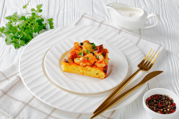 Cheesy tamale pie on a white plate with cutlery