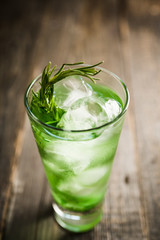 Sweet tequila based green cocktail with tarragon and rosemary. Selective focus. Shallow depth of field.