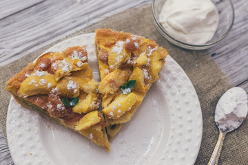 Apple pie for Breakfast on a white plate, wooden background