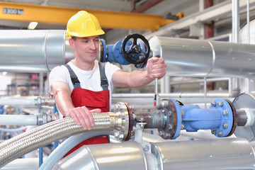Industriearbeiter repariert eine Anlage - Mechaniker am Arbeitsplatz // Mechanics repair a machine in a modern industrial plant - profession and teamwork