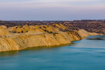 Fototapeta na wymiar Lake with sandy bank in the abandoned coal quarry