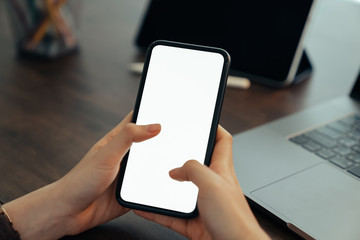 Hand holding blank screen of smartphone on the desk office and for graphic display montage.