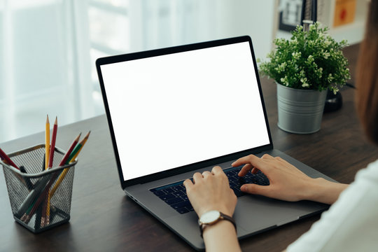 Hand using laptop with blank copy space screen for your advertisement. on the table in office.