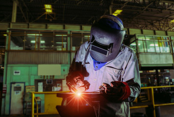 Industrial Worker process laborer by tig weld torch at the factory welding steel structure.