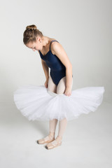 Naklejka premium Young ballerina preparing for dance in the studio