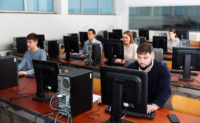 Group of people learning to use computers in classroom