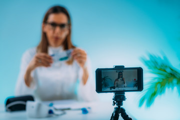 Telehealth – Medical doctor recording video instructions for patient. Showing medication for therapy