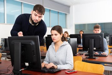 Fototapeta na wymiar Teacher helping young student in computer class