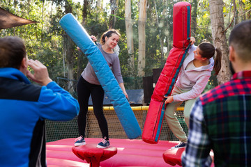 Fototapeta na wymiar Female friends fighting by inflatable logs