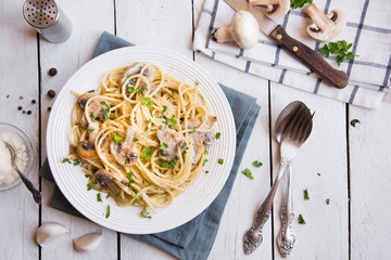 Spaghetti pasta with mushrooms, creamy sause and parsley on white