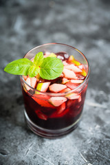 Old fashioned cocktail with blackberry liqueur and apple slices on rustic background. Selective focus. Shallow depth of field.
