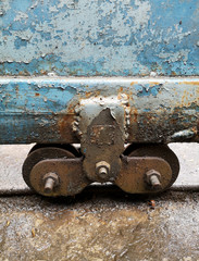 The castors of the old blue iron doors are rusted in wet and dirty floor
