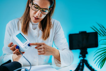 Telehealth – Medical doctor recording video instructions for patient and demonstrating how to...